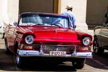HAVANA, CUBA - 18 Kasım 2017: Havana, Küba sokaklarında eski renkli klasik araba. Ambargo nedeniyle Amerikan arabaları hala kullanılıyor ve turistler için taksi veya taşımacılık görevi görüyor.