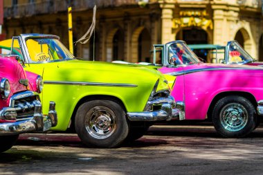 HAVANA, CUBA - 18 Kasım 2017: Havana, Küba sokaklarında eski renkli klasik araba. Ambargo nedeniyle Amerikan arabaları hala kullanılıyor ve turistler için taksi veya taşımacılık görevi görüyor.