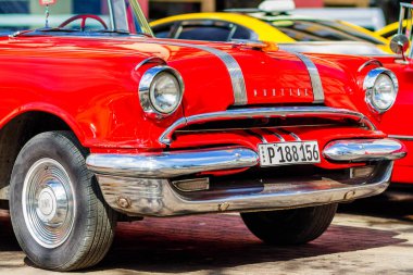 HAVANA, CUBA - 18 Kasım 2017: Havana, Küba sokaklarında eski renkli klasik araba. Ambargo nedeniyle Amerikan arabaları hala kullanılıyor ve turistler için taksi veya taşımacılık görevi görüyor.