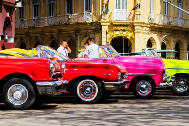 HAVANA, CUBA - 18 Kasım 2017: Havana, Küba sokaklarında eski renkli klasik araba. Ambargo nedeniyle Amerikan arabaları hala kullanılıyor ve turistler için taksi veya taşımacılık görevi görüyor.
