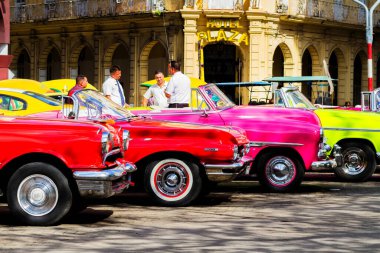 HAVANA, CUBA - 18 Kasım 2017: Havana, Küba sokaklarında eski renkli klasik araba. Ambargo nedeniyle Amerikan arabaları hala kullanılıyor ve turistler için taksi veya taşımacılık görevi görüyor.