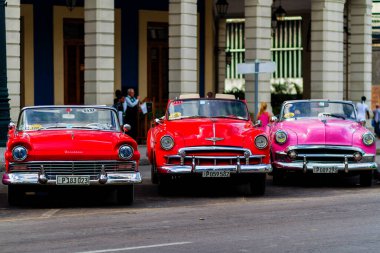 HAVANA, CUBA - 18 Kasım 2017: Havana, Küba sokaklarında eski renkli klasik araba. Ambargo nedeniyle Amerikan arabaları hala kullanılıyor ve turistler için taksi veya taşımacılık görevi görüyor.