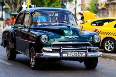 HAVANA, CUBA - 18 Kasım 2017: Havana, Küba sokaklarında eski renkli klasik araba. Ambargo nedeniyle Amerikan arabaları hala kullanılıyor ve turistler için taksi veya taşımacılık görevi görüyor.