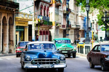 HAVANA, CUBA - 14 Kasım 2017: İnsanlar, eski arabalar ve renkli binaların olduğu tipik sokak sahnesi. 2 milyondan fazla nüfusuyla Havana, Küba 'nın başkenti ve Karayipler' in en büyük şehridir.