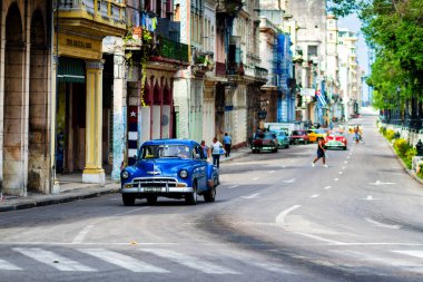 HAVANA, CUBA - 14 Kasım 2017: İnsanlar, eski arabalar ve renkli binaların olduğu tipik sokak sahnesi. 2 milyondan fazla nüfusuyla Havana, Küba 'nın başkenti ve Karayipler' in en büyük şehridir.