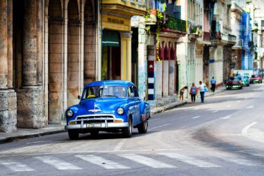HAVANA, CUBA - 14 Kasım 2017: İnsanlar, eski arabalar ve renkli binaların olduğu tipik sokak sahnesi. 2 milyondan fazla nüfusuyla Havana, Küba 'nın başkenti ve Karayipler' in en büyük şehridir.