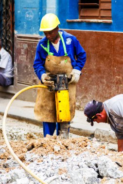 HAVANA, CUBA - 30 Kasım 2017: Pnömatik çekiç matkabı olan işçi yol inşaatında asfalt kırıyor