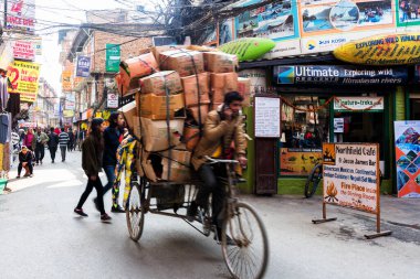 KATHMANDU, NEPAL - 10 Aralık 2018: Adam şehir merkezindeki Katmandu Thamel bölgesinde faytonuna biniyor. Nepal 'in çekçek sürücülerinin yıllık ortalama geliri sadece 3800 Amerikan doları.