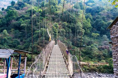Nepal, Himalaya dağlarındaki Annapurna Pisti 'nde popüler bir turizm beldesi üzerindeki asma köprü.
