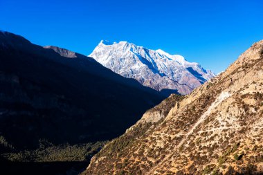 Nepal 'de popüler bir turizm beldesi olan Annapurna Circuit Trail' in panoramik manzarası. Thorong La ya da Thorung La geçidine ana kampa giden yol..