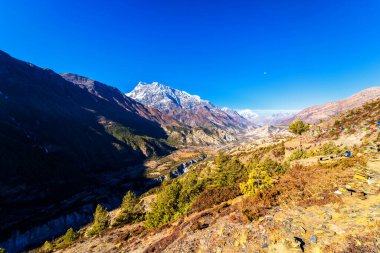 Nepal 'de popüler bir turizm beldesi olan Annapurna Circuit Trail' in panoramik manzarası. Thorong La ya da Thorung La geçidine ana kampa giden yol..