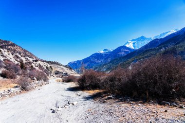 Nepal 'de popüler bir turizm beldesi olan Annapurna Circuit Trail' in panoramik manzarası. Thorong La ya da Thorung La geçidine ana kampa giden yol..
