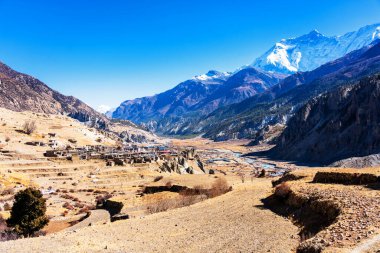 Nepal 'de popüler bir turizm beldesi olan Annapurna Circuit Trail' in panoramik manzarası. Thorong La ya da Thorung La geçidine ana kampa giden yol..