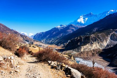 Nepal 'de popüler bir turizm beldesi olan Annapurna Circuit Trail' in panoramik manzarası. Thorong La ya da Thorung La geçidine ana kampa giden yol..