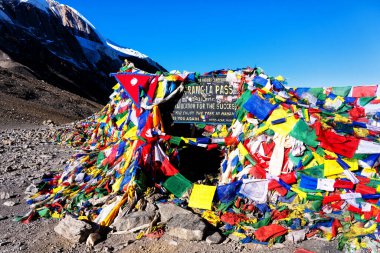 Geçitte Tibet taş yığını ve renkli bayraklar, Himalayalar, Nepal. Thoroang La Pass.
