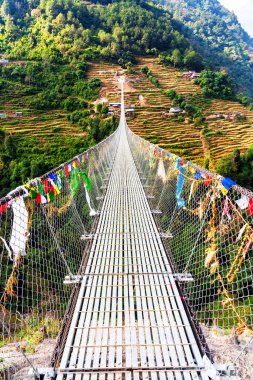 Nepal, Himalaya dağlarındaki Annapurna Pisti 'nde popüler bir turizm beldesi üzerindeki asma köprü.