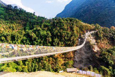 Nepal, Himalaya dağlarındaki Annapurna Pisti 'nde popüler bir turizm beldesi üzerindeki asma köprü.