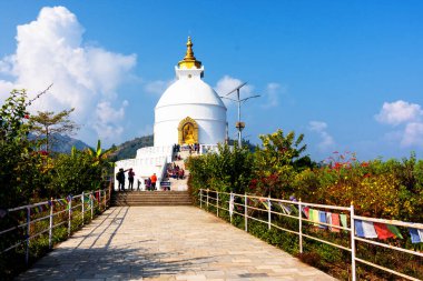 POKHARA, NEPAL - DEV 8, 2018: Pokhara yakınlarında dünya barışı stupası, en iyi stupalardan biri. Sergide Annapurna aralığı ve Pokhara kenti hakkında görüşler sunuluyor.