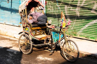 KATHMANDU, NEPAL - 10 Aralık 2018: İnsan müşterilerinin gelmesini beklerken triportöründe uyur.