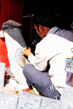 KATHMANDU, NEPAL - 10 Aralık 2018: Nepalli zanaatkar dekorasyon için taş levhaları oyuyor