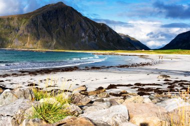 Kristal turkuaz suyla yıkanmış beyaz kumlar. Norveç, Lofoten Adaları 'ndaki Ramberg plajından deniz manzarası