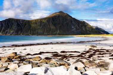 Kristal turkuaz suyla yıkanmış beyaz kumlar. Norveç, Lofoten Adaları 'ndaki Ramberg plajından deniz manzarası