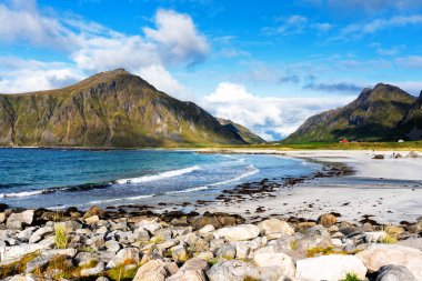 Kristal turkuaz suyla yıkanmış beyaz kumlar. Norveç, Lofoten Adaları 'ndaki Ramberg plajından deniz manzarası