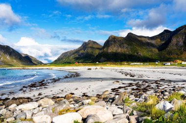 Kristal turkuaz suyla yıkanmış beyaz kumlar. Norveç, Lofoten Adaları 'ndaki Ramberg plajından deniz manzarası