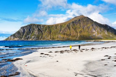 Kristal turkuaz suyla yıkanmış beyaz kumlar. Norveç, Lofoten Adaları 'ndaki Ramberg plajından deniz manzarası