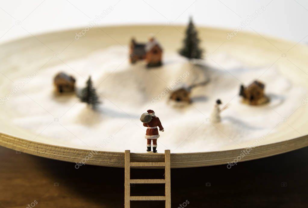  Santa stand on rim of wooden plate with  wooden ladder and small village view in white snow
