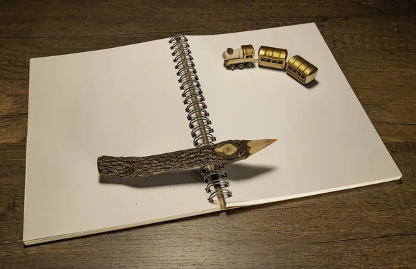 1つの木製の鉛筆で空白のノートブック上のゴールデントレイン — ストック写真