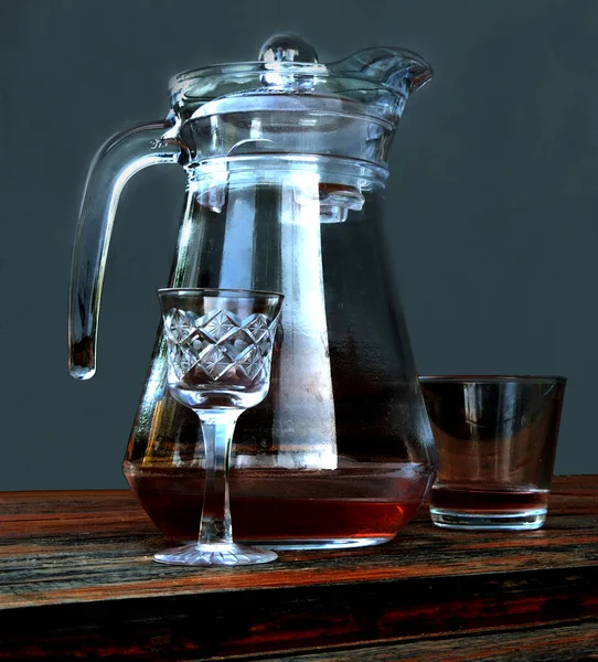 Glass jug, glass and shot glass with a drink