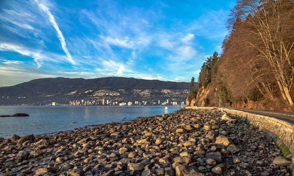 Stanley Park Vancouver, kayalık plaj, set ve Set düşük tide zaman. Sonbahar, neredeyse çıplak ağaçlar, şehir merkezinden Batı Vancouver güzel bir bulutlu gökyüzü karşı koyun karşı kıyısında. British Columbia, Kanada