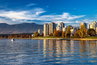 Vancouver şehir, şehir merkezi ve Stanley Park dağ ve mavi bulutlu bir gökyüzü arka plan, binalar ve gökyüzü güzel yansıması üzerinde güzel manzarası. 