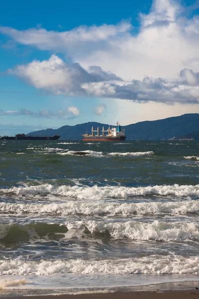 Vancouver limanı, karla kaplı dağın arka plan sahnesinde güneşli rüzgarlı bir günde liman beyaz dalgalar yükleme bekliyor okyanus tankerleri 