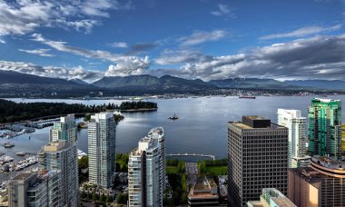 Vancouver Limanı'nın karşı kıyısındavancouver ve Kuzey Vancouver şehir merkezinden Vancouver Limanı'nın bir dağ sırası ve bulutlu gökyüzünün arka planında havadan görünümü