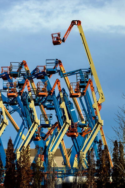 Rental construction  equipment. Boom lifts  with raised platforms are on-site on   for the equipment for rent