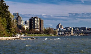Vancouver Harbor, Downtown ve Stanley Park'ta mavi fırtınalı gökyüzünün arka planında Vancouver şehrinin silueti 