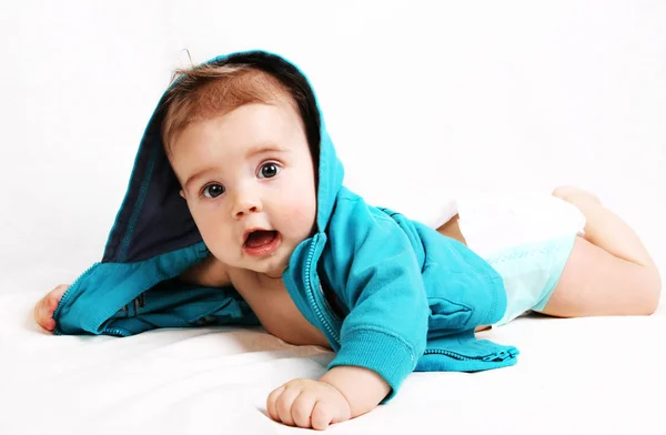 Baby Een Hoodie Liggend Zijn Buik Een Witte Achtergrond — Stockfoto