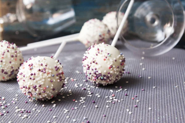 Huisgemaakte snoepjes in witte chocolade met gekleurd poeder op tafel — Stockfoto