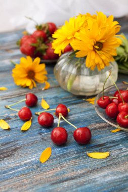 Ahşap bir masada Yaz: bakla tatlı kiraz, yeşil bezelye, 