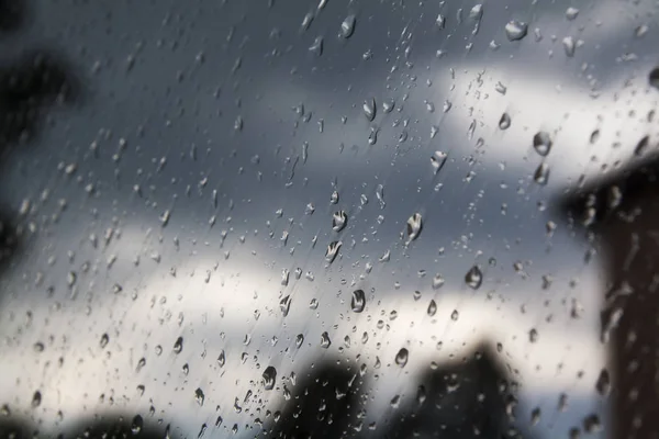 Regentropfen am Fenster und wolkenverhangener Himmel im Hintergrund — Stockfoto