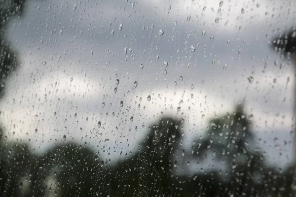 Regentropfen am Fenster und wolkenverhangener Himmel im Hintergrund — Stockfoto