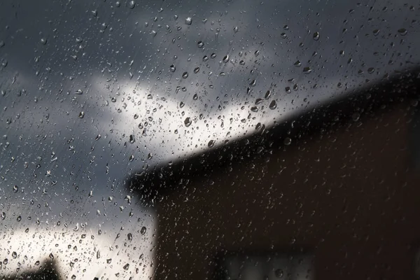 Regentropfen am Fenster und wolkenverhangener Himmel im Hintergrund — Stockfoto