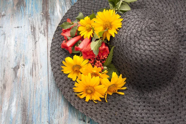 Літня жіноча шапка з квітами на дерев'яному фоні — стокове фото