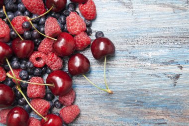 Ahududu, kiraz, boyalı yüzeyde yaban mersini