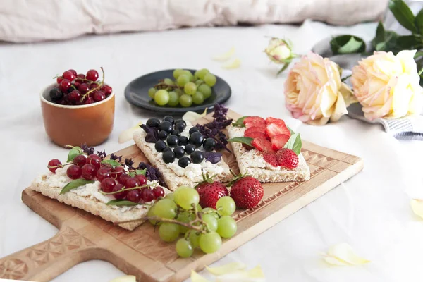 summer breakfast in bed with cheese and berry sandwiches on brea