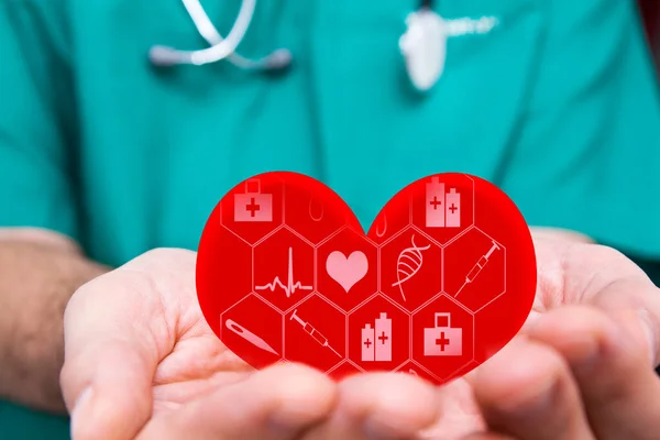 의사 손에 의학용 아이콘이 들어 있는 빨간 심장. 의료 상의 개념 — 스톡 사진