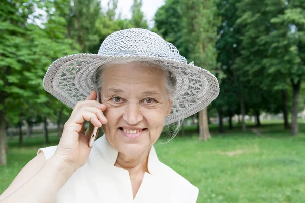 Senior mulher de chapéu feliz fala ao telefone — Fotografia de Stock