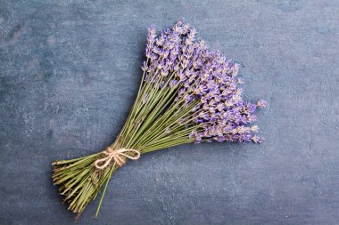 Düz lavanta çiçekleri koyu desenli arka planda bir topuz içinde yatıyordu.